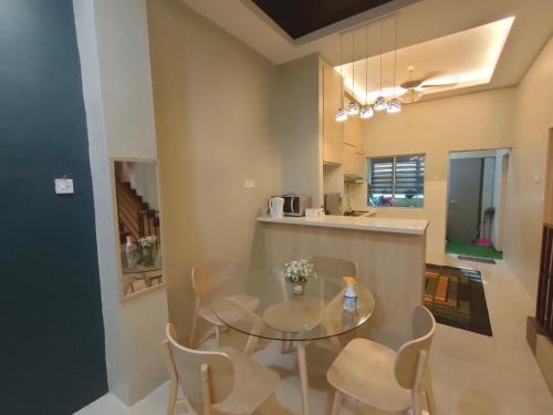 una sala da pranzo con tavolo e sedie in vetro di Homestay Gerik Le rizq Homestay~ Heart of Gerik ~ Cozy a Gerik