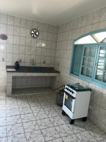 uma cozinha com um fogão, uma janela e um balcão em Castelinho de Ibicuí em Mangaratiba