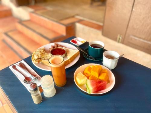 a table with two plates of breakfast food and drinks at Mystic Manor Stonetown B&B in Stone Town