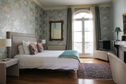 ein Schlafzimmer mit großem Bett und Fenster in der Unterkunft La Maison Jules in Tours