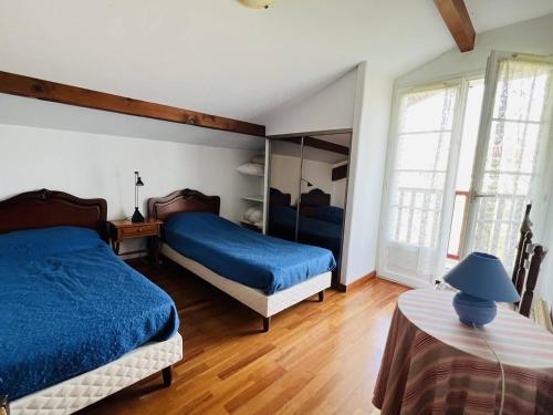 - une chambre avec 2 lits dotés de draps bleus et de parquet dans l'établissement Belle villa basque panoramique, 6 couchages, à 7 km de Cambo et des Thermes - FR-1-495-29, à Cambo-les-Bains