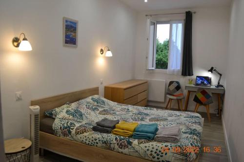 a bedroom with a bed and a desk and a window at Castellane : T2 spacieux - Vue Port - WIFI in Port-Vendres