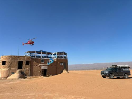 a helicopter flying over a building in the desert at désert tours & Hôtel Titanic lac irik in Foum Zguid