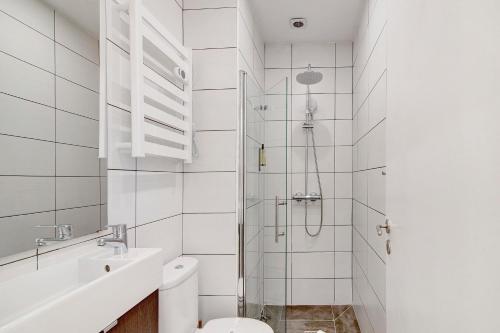 a bathroom with a shower and a toilet and a sink at Bougainvillea House in Faro