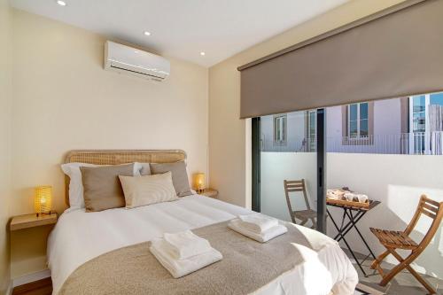 a bedroom with a large bed and a balcony at Bougainvillea House in Faro