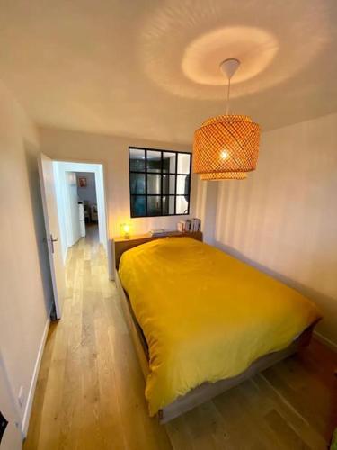 une chambre avec un lit jaune avec une fenêtre dans l'établissement Cosy Cocoon in St-Ouen/Flea Mrkt, à Saint-Ouen