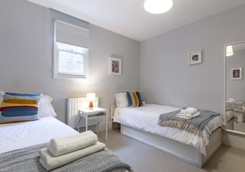 a bedroom with two beds and a window at Fern Cottage - Whitstable in Whitstable