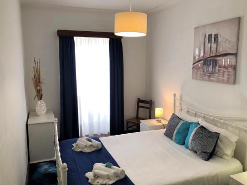 - une chambre avec un lit et une grande fenêtre dans l'établissement PDL Central Apartments - Three, à Ponta Delgada