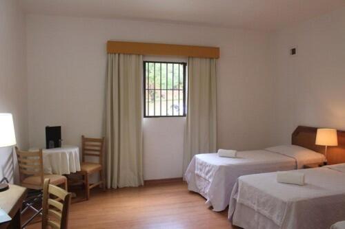 a hotel room with two beds and a window at Paradies Hotel Express in Jarinu