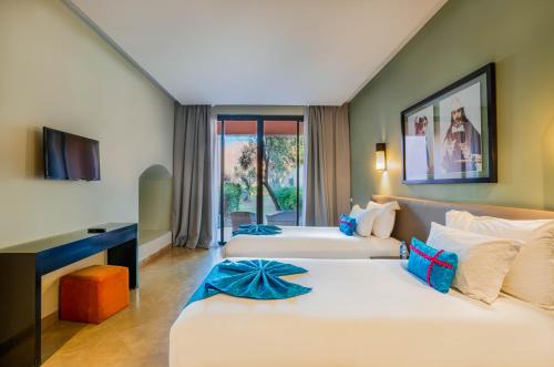 um quarto de hotel com duas camas e uma televisão em Al Maaden Villa Hotel & Spa em Marrakech