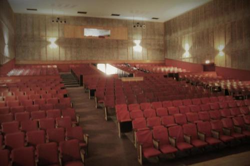 an empty auditorium with red seats in an auditorium at Backstage Theatre Room in Tsumeb