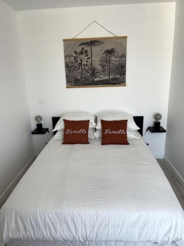 - un lit blanc avec 2 oreillers rouges dans l'établissement Eiffel Tour Cosy terracota, à Paris