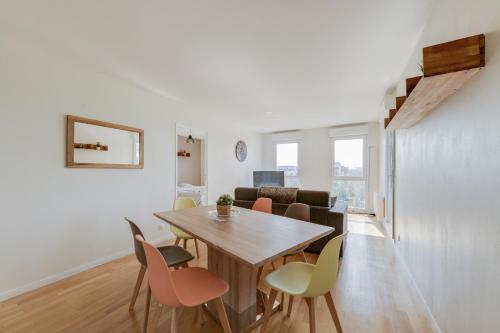 - une salle à manger et un salon avec une table et des chaises en bois dans l'établissement Chic apartment with superb view of the eiffel tower, à Saint-Denis