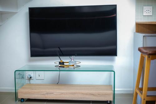 a glass table with a television on a wall at Urban Oasis Apartments at Freedom Plaza in Windhoek