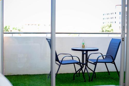 a small table and two chairs on a balcony at Urban Oasis Apartments at Freedom Plaza in Windhoek