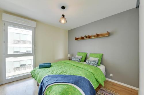 a bedroom with a green bed and a window at Chic apartment with superb view of the eiffel tower in Saint-Denis