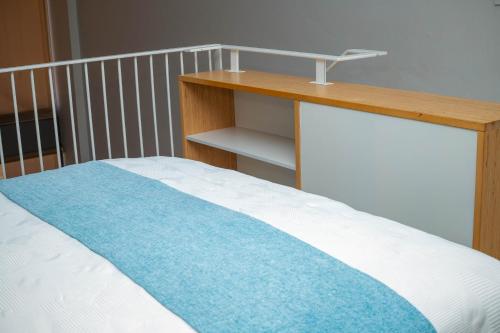 a bedroom with a bed with a wooden desk at Urban Oasis Apartments at Freedom Plaza in Windhoek