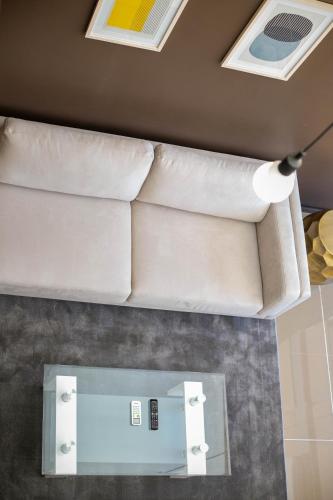 a living room with a white couch and a mirror at Urban Oasis Apartments at Freedom Plaza in Windhoek