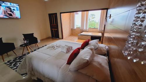 1 dormitorio con 1 cama grande y TV en Luar de Minas suites en Lavras Novas