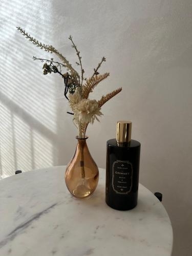 a vase with flowers and a candle on a table at Modern Elegance in historical City Center in Trier