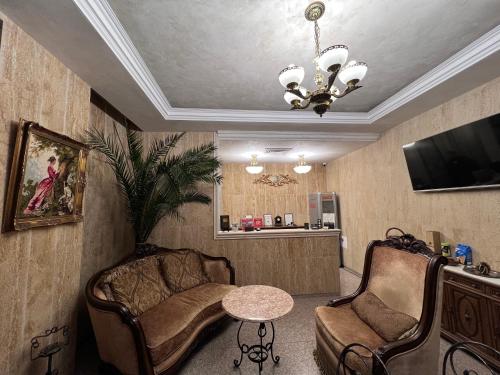 Pernik的住宿－Хотел Антик，客厅配有两把椅子和一张桌子