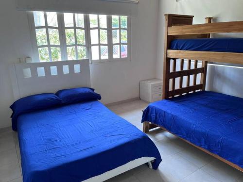 1 dormitorio con 2 literas con sábanas azules en El Mejor Lugar para descansar cabaña OASIS, en San Antero