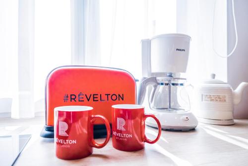 two red coffee mugs sitting on a kitchen counter at Revelton Studios Karlovy Vary in Karlovy Vary