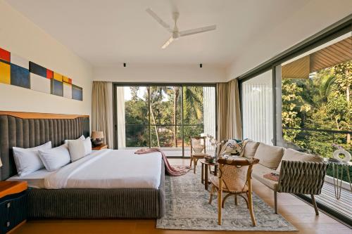 a bedroom with a bed and a couch at The Banyan Tree Villa B1 by Stay ALYF, Siolim in Siolim