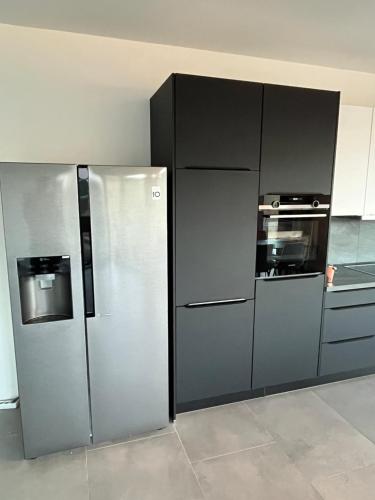 a kitchen with a stainless steel refrigerator and an oven at Luxus Neubauwohnung mit Blick auf den Phönix-See in Dortmund