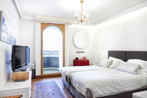 une chambre avec deux lits et une télévision à écran plat dans l'établissement L'Abri du Repos - Appt vue sur le port, à Barneville-Carteret