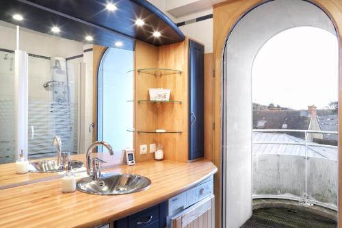 La salle de bains est pourvue de 2 lavabos et d'une grande fenêtre. dans l'établissement L'Abri du Repos - Appt vue sur le port, à Barneville-Carteret