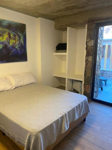a bedroom with a bed with a painting on the wall at Villa Narcisa in Purmamarca
