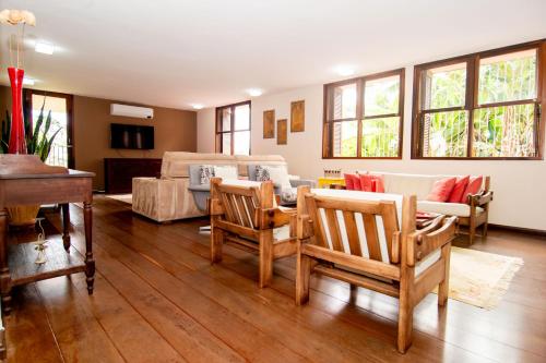 uma sala de estar com um sofá e cadeiras e um piano em Casarão com Hidromassagem, 450m da UFSC UR7452 em Florianópolis