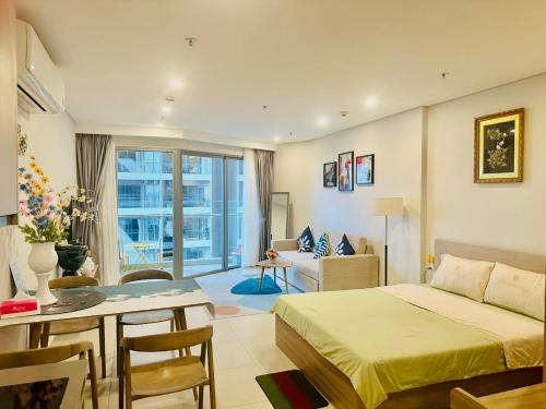 a bedroom with a bed and a dining room at The Song Luxury Vung Tau Apartment - QUỲNH's Homestay in Vung Tau