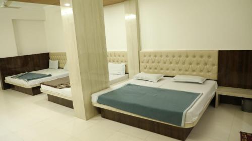 a bedroom with two beds and a mirror at Hotel Sahil 4 Min Distance from Dargah in Ajmer