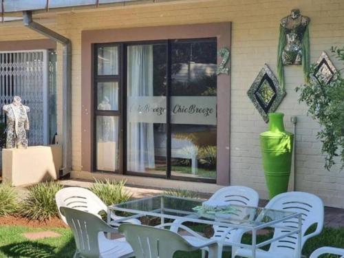 a glass table and chairs in front of a store at Chic Breeze in Bloemfontein
