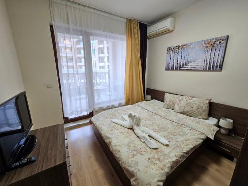 a bedroom with a bed with two white towels on it at Elegantz Apartments 2 in Varna City