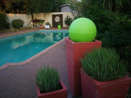 a large green ball sitting next to a swimming pool at Chic Breeze in Bloemfontein