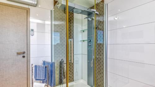 um chuveiro com uma porta de vidro na casa de banho em Villa Over The Hilltop em Bencani