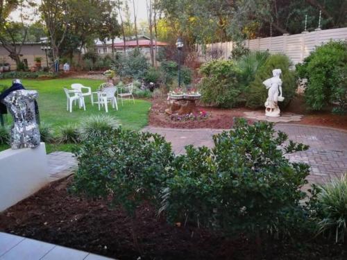 a garden with a statue and a table and chairs at Chic Breeze in Bloemfontein