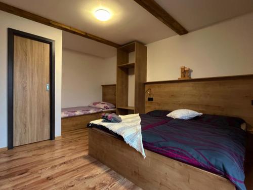 Schlafzimmer mit einem großen Bett mit einem Kopfteil aus Holz in der Unterkunft Chata POD HOUBOVÝM VRCHEM 2 in Horní Planá