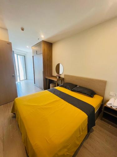 a large yellow bed in a room with a mirror at The Song Luxury Vung Tau Apartment - QUỲNH's Homestay in Vung Tau