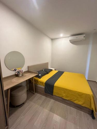 a bedroom with a yellow bed and a desk at The Song Luxury Vung Tau Apartment - QUỲNH's Homestay in Vung Tau