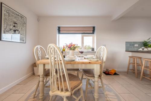 a dining room with a wooden table and chairs at Deerwood in Grimston