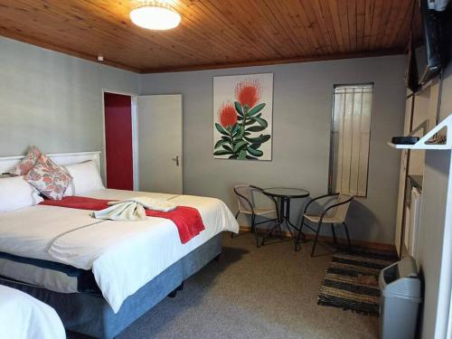 a bedroom with a bed and a table with chairs at Chic Breeze in Bloemfontein
