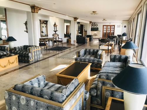 - un salon avec des canapés, des chaises et une table dans l'établissement The Sarai Suites, Murree, à Murree