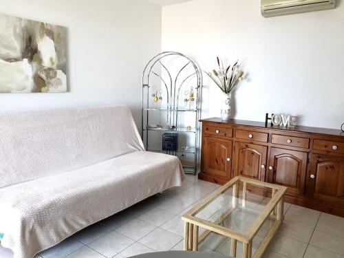 un salon avec un canapé et une table en verre dans l'établissement Appartement en rez de villa vue mer, à Monticello