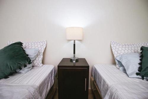 a bedroom with two beds and a lamp on a night stand at Bed and breakfast Tía Mema in Santa Ana