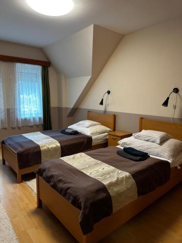 um quarto de hotel com duas camas e uma janela em Gyarmati Panzió & Étterem em Veszprém