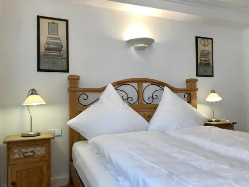 1 Schlafzimmer mit 2 Betten mit weißer Bettwäsche und 2 Lampen in der Unterkunft Ferienwohnung Am Stadtpark - Charmant, seenah, zentral in historischem Gebäude in Lindau